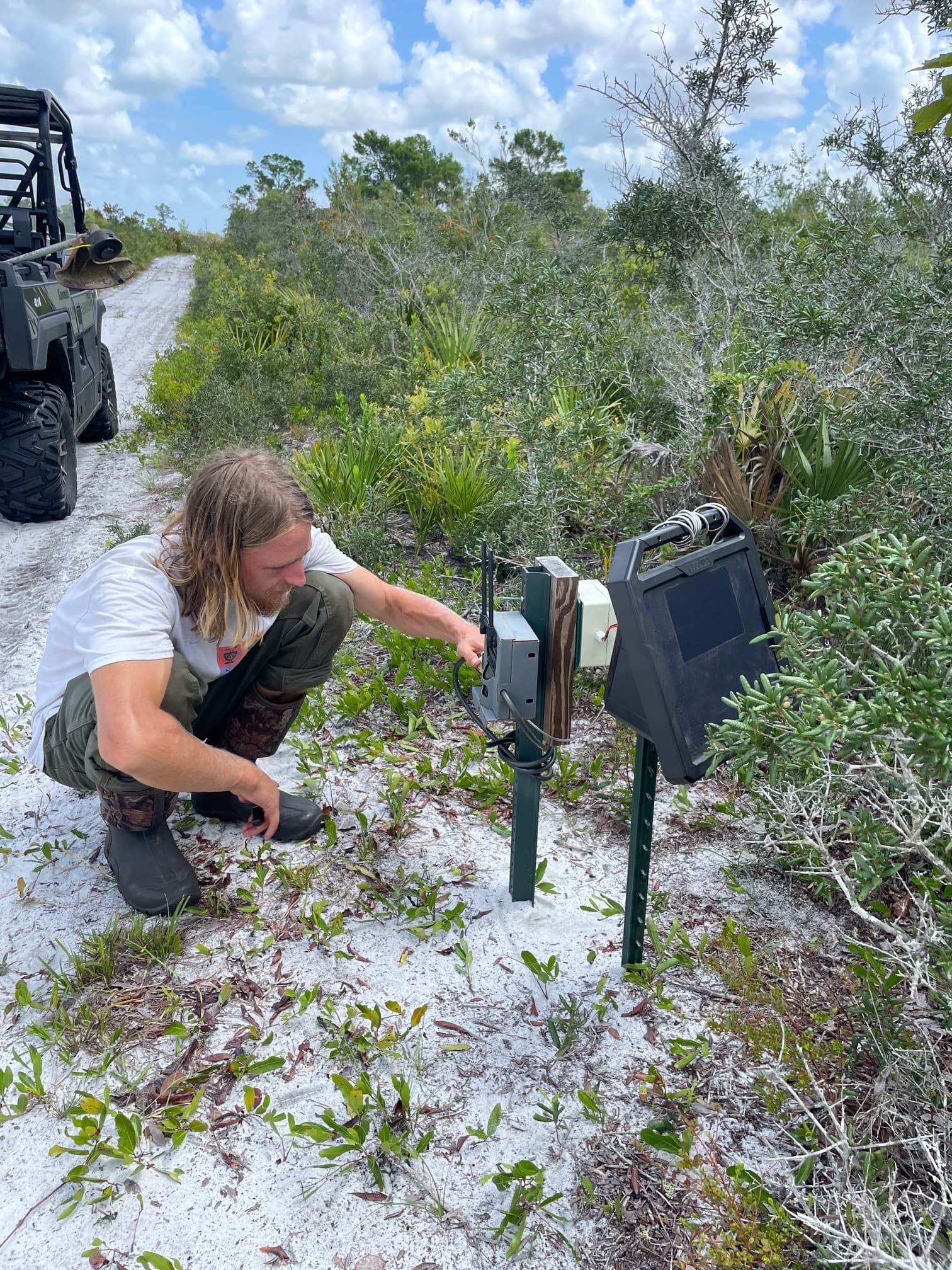 Photo 1 Caption: Archbold Research Assistant Fin Ouweleen performs monthly maintenance on a Corridor Observatory wildlife monitoring site.
