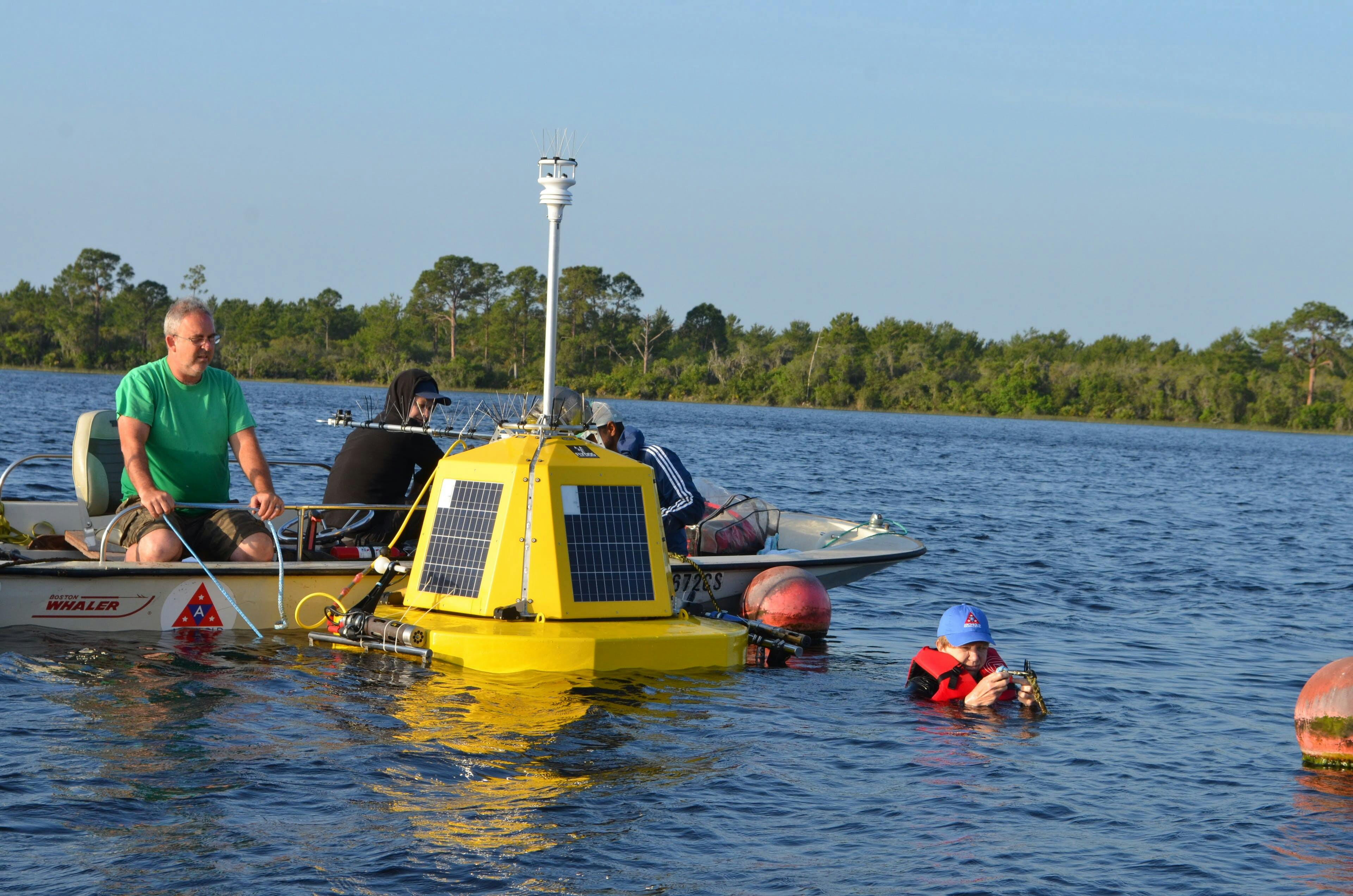 Kevin Main Dr. Amartya Saha (Archbold), Andri Laidre (Flydog) and in the water Dr. Evelyn Gaiser (FIU) deploying buoy in Lake Annie, April 1-2, 2022. Photo by Gabe Kamener (FIU).